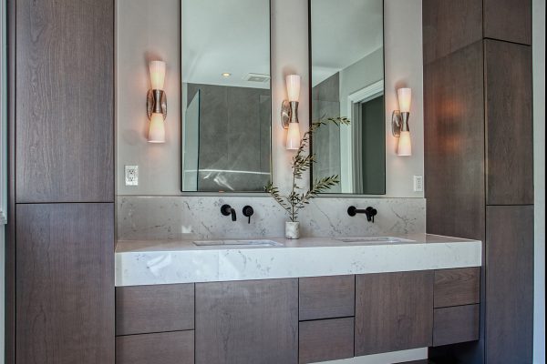 Twilight Bath – Featuring cabinetry by Bellmont 1600 in Twilight with a floating vanity and double storage towers. Countertops by Vadara with a 6” miter cut edge. Wall mount faucets in black.